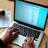 Hands typing on a laptop with a resume document on screen