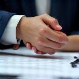 Two hands shaking over a contract